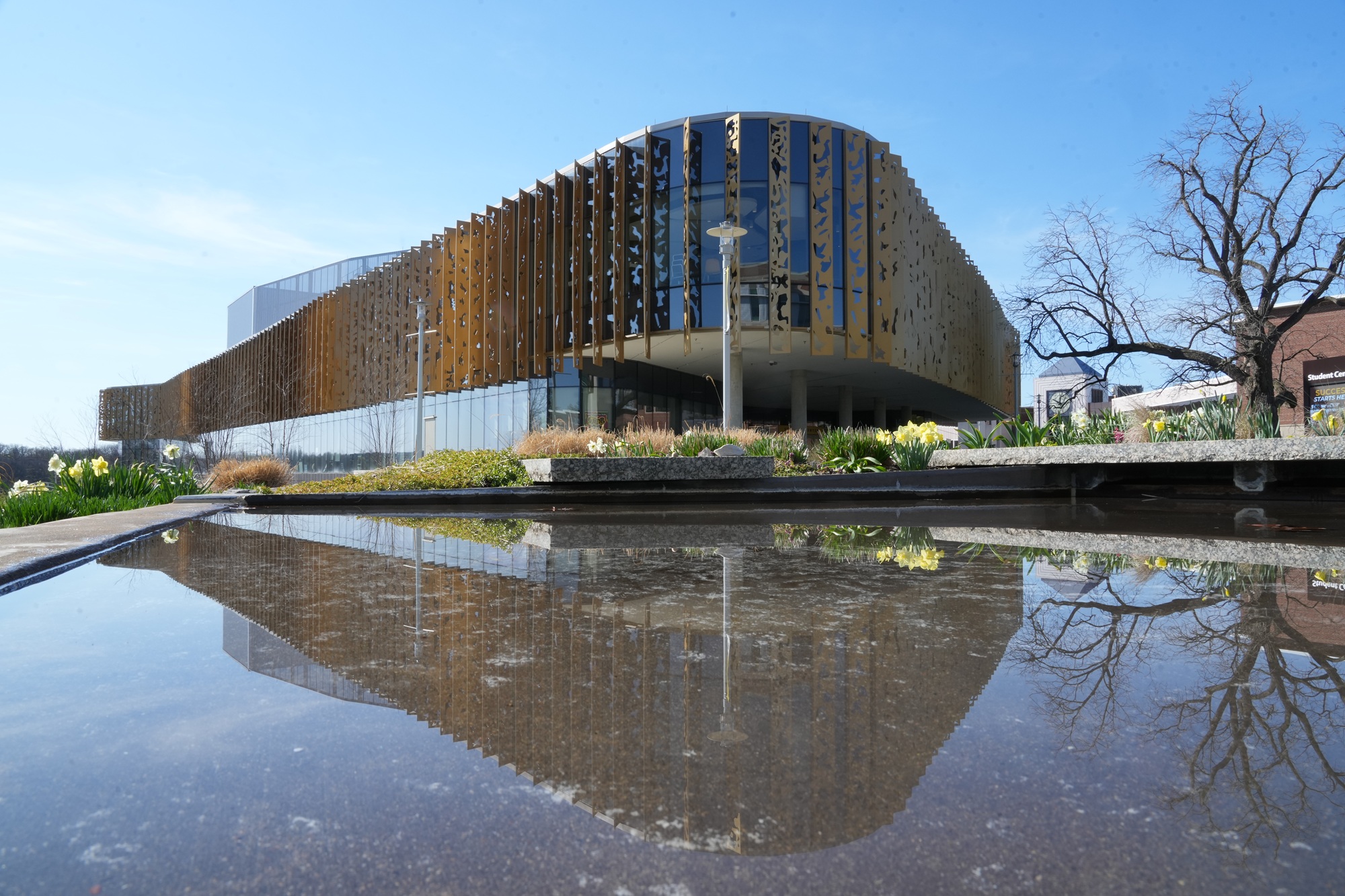 Student centre reflected in plaza pool
