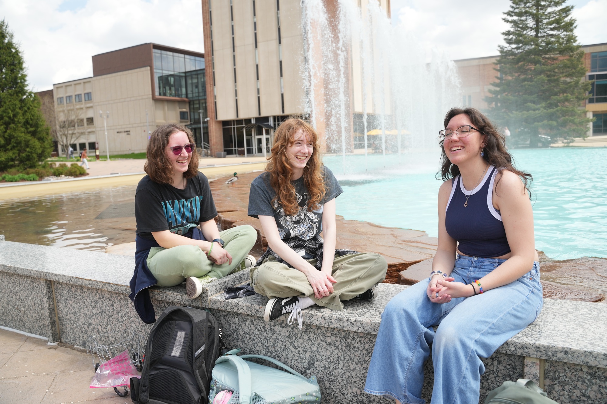 Students relaxing by the campus fountain